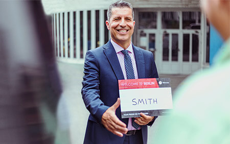 Smiling Welcome driver holding a name sign
