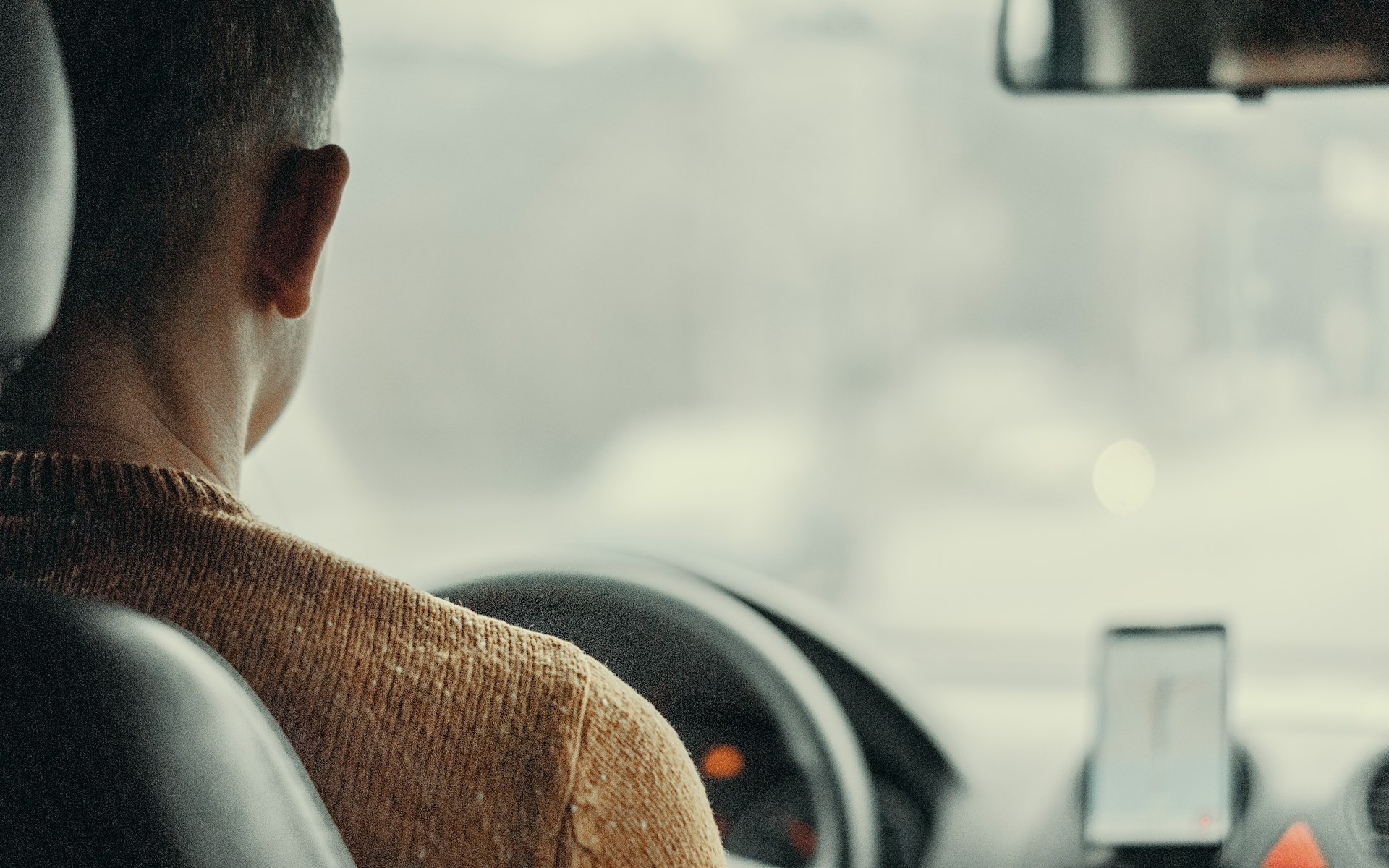 Male driver at the wheel in a city setting